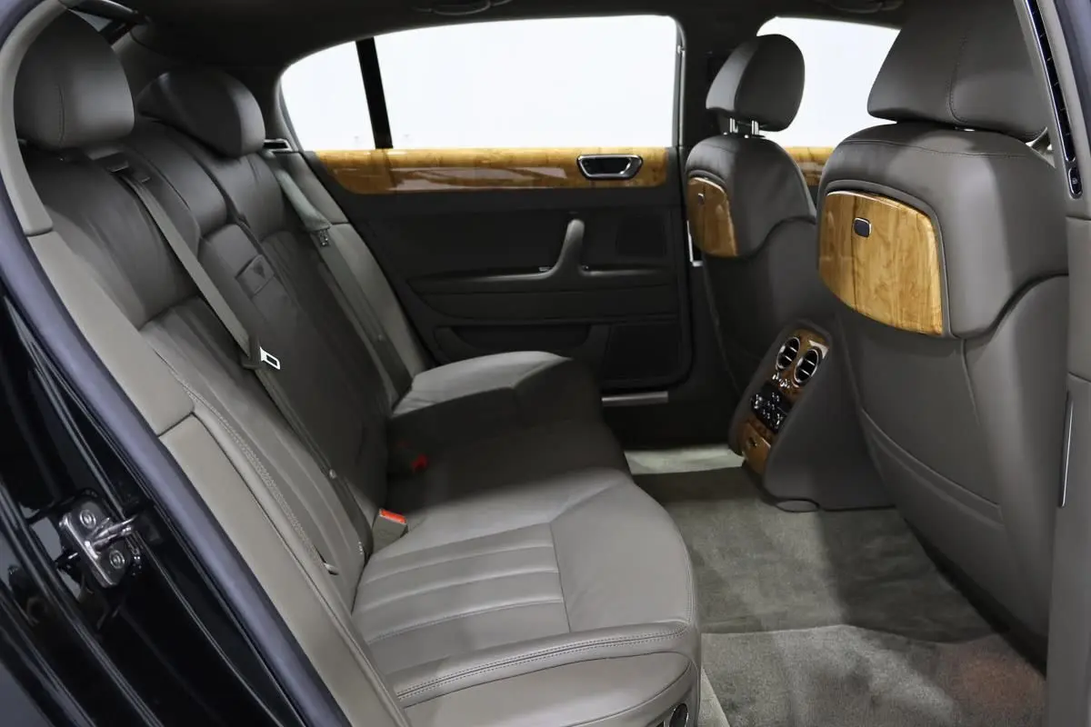 Vue intérieure arrière côté gauche du Bentley Continental Flying Spur 2006, cuir gris et boiseries élégantes.