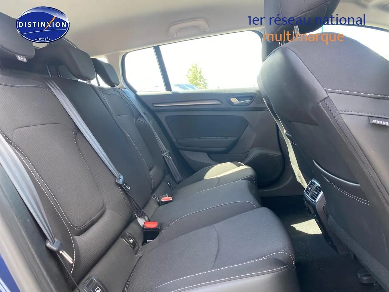 Vue intérieure côté droit sur la banquette arrière noire avec ceintures et appuie-têtes du Renault Mégane IV Estate bleu.