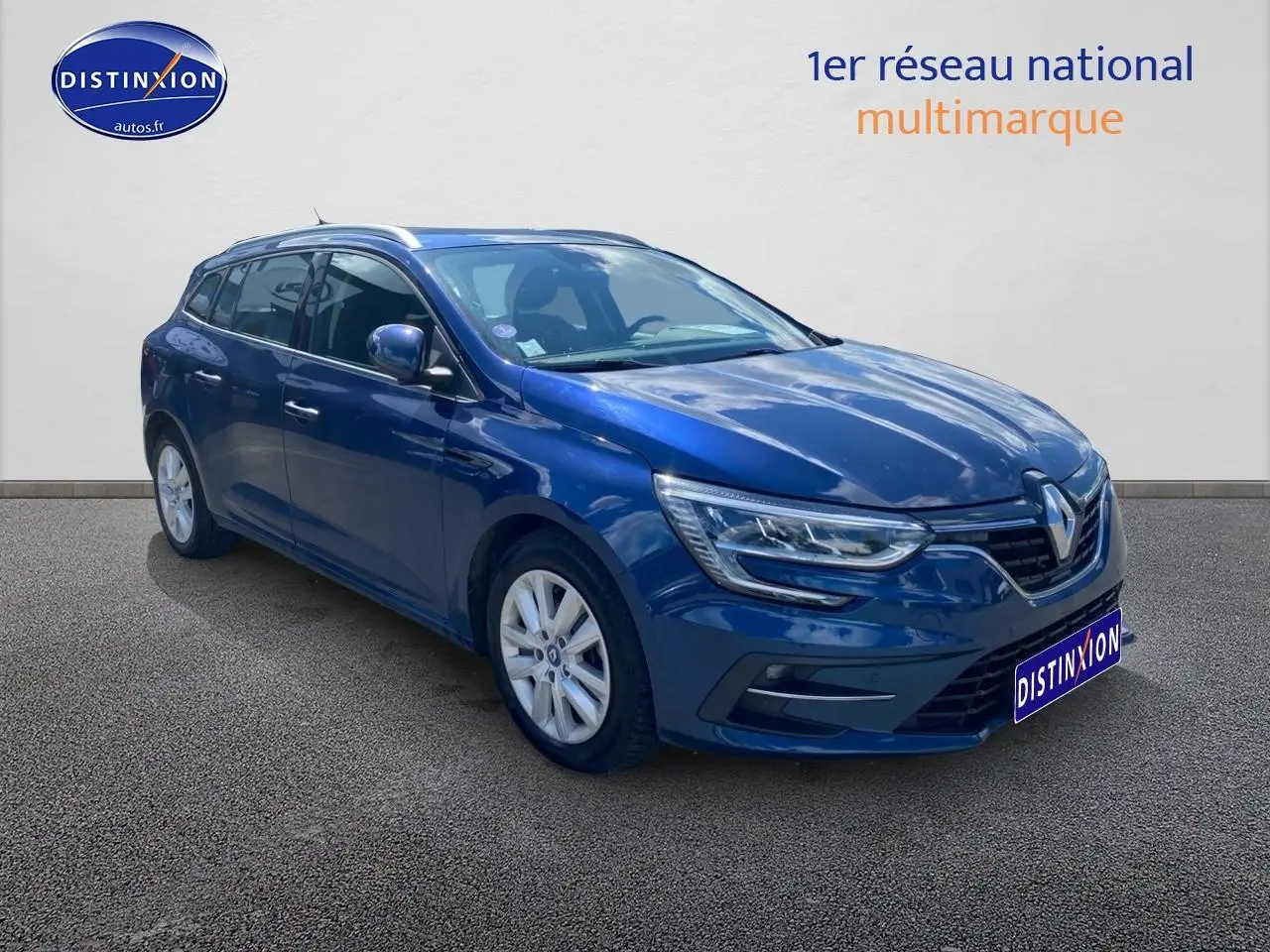 Renault Mégane IV Estate bleu en 3/4 avant droit, avec jantes alu et feux LED distinctifs.