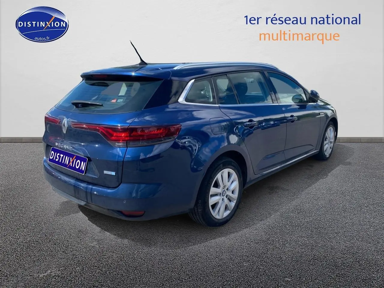 Vue 3/4 arrière droite d'une Renault Mégane IV Estate bleu métallisé avec jantes alu et vitres teintées.