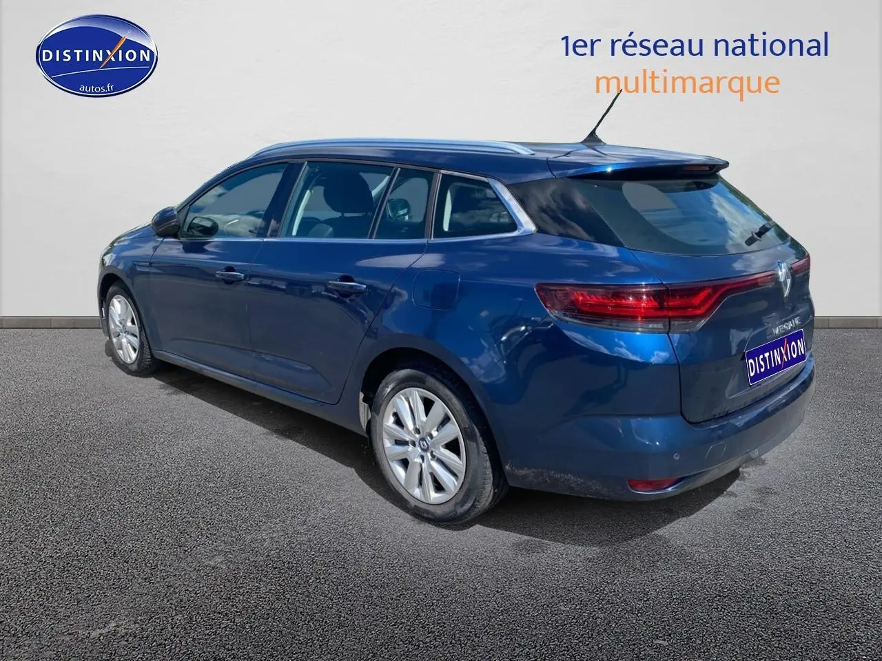 Renault Mégane IV Estate bleu, vue 3/4 arrière côté gauche, jantes alu et feux arrière LED visibles.
