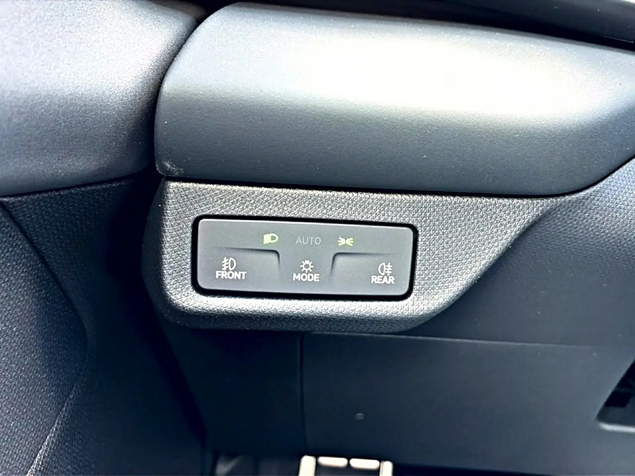 Détail du tableau de bord noir du CUPRA TERRAMAR 2026 montrant les commandes d’éclairage automatiques.