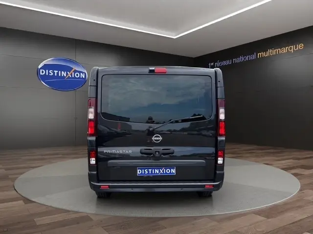 Vue arrière d'un Nissan Primastar noir, avec portes arrière fermées et logo Distinxion visible.