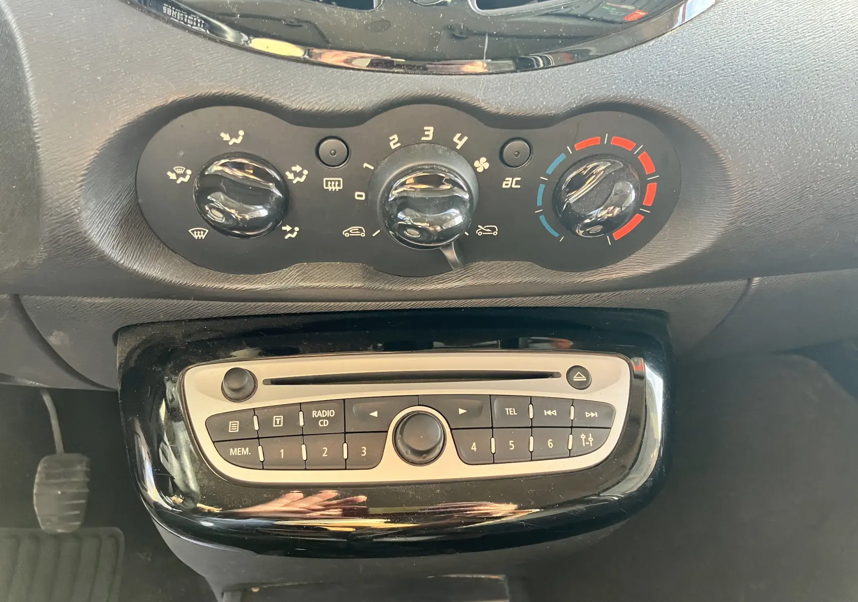 Tableau de bord de Renault Twingo II 75CH ESS 2011, vue rapprochée sur commandes de climatisation et radio intégrée.