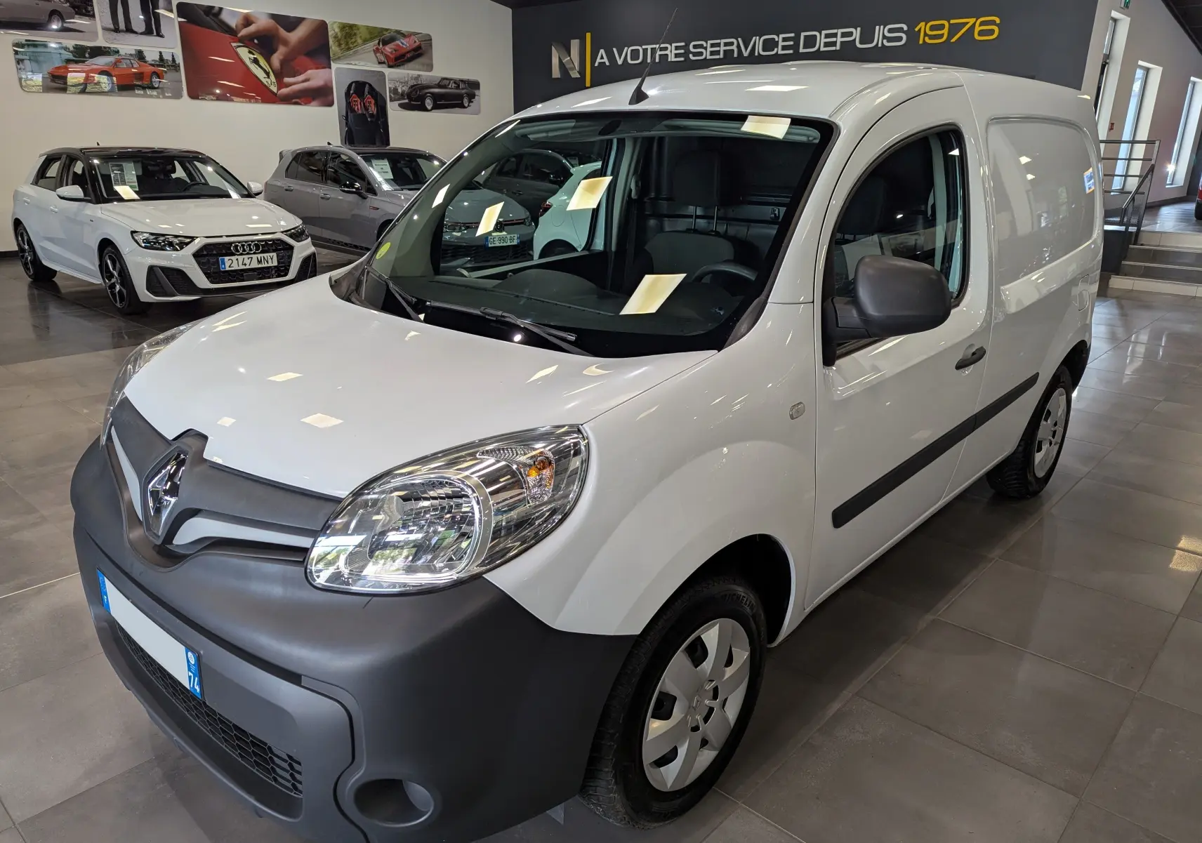Renault Kangoo Express blanc minéral vu en 3/4 avant droit, avec pare-chocs noir mat et vitrage teinté.