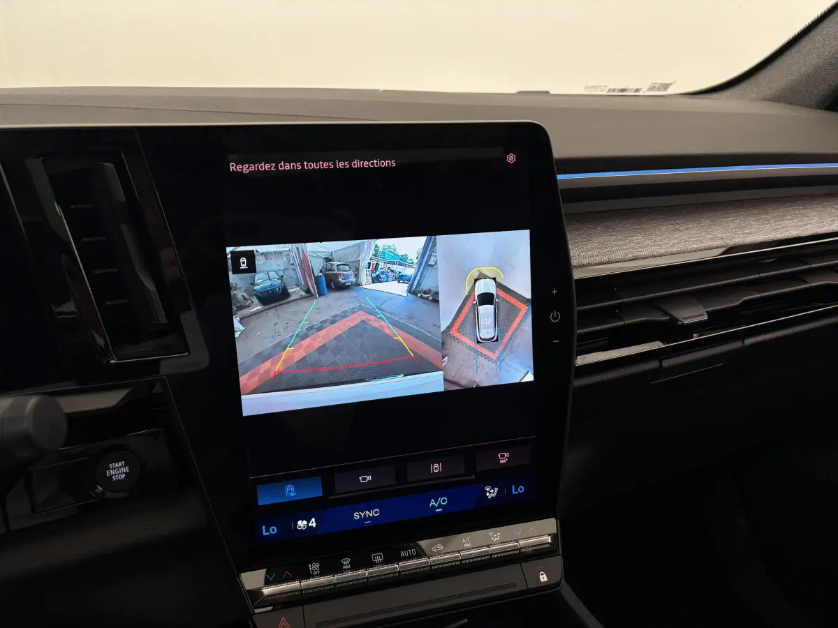 Vue rapprochée de l'écran tactile central du Renault Austral 2025 affichant la caméra de recul et l'aide au stationnement.