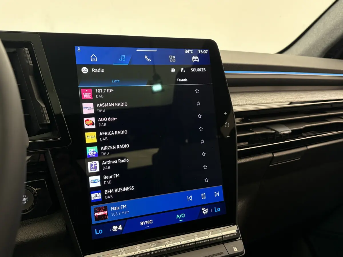 Écran tactile central 12 pouces du tableau de bord du Renault Austral blanc, avec commandes climatisation visibles.