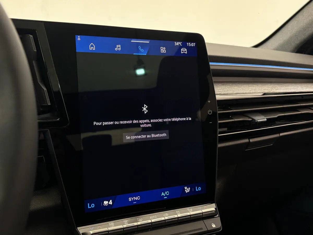 Écran tactile central affichant la connexion Bluetooth dans l'habitacle noir du Renault Austral blanc 2025.