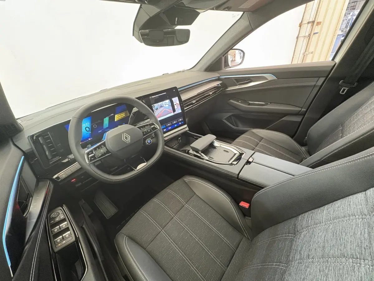 Intérieur du Renault Austral 2025 vu côté conducteur, avec tableau de bord numérique et sièges tissu gris.