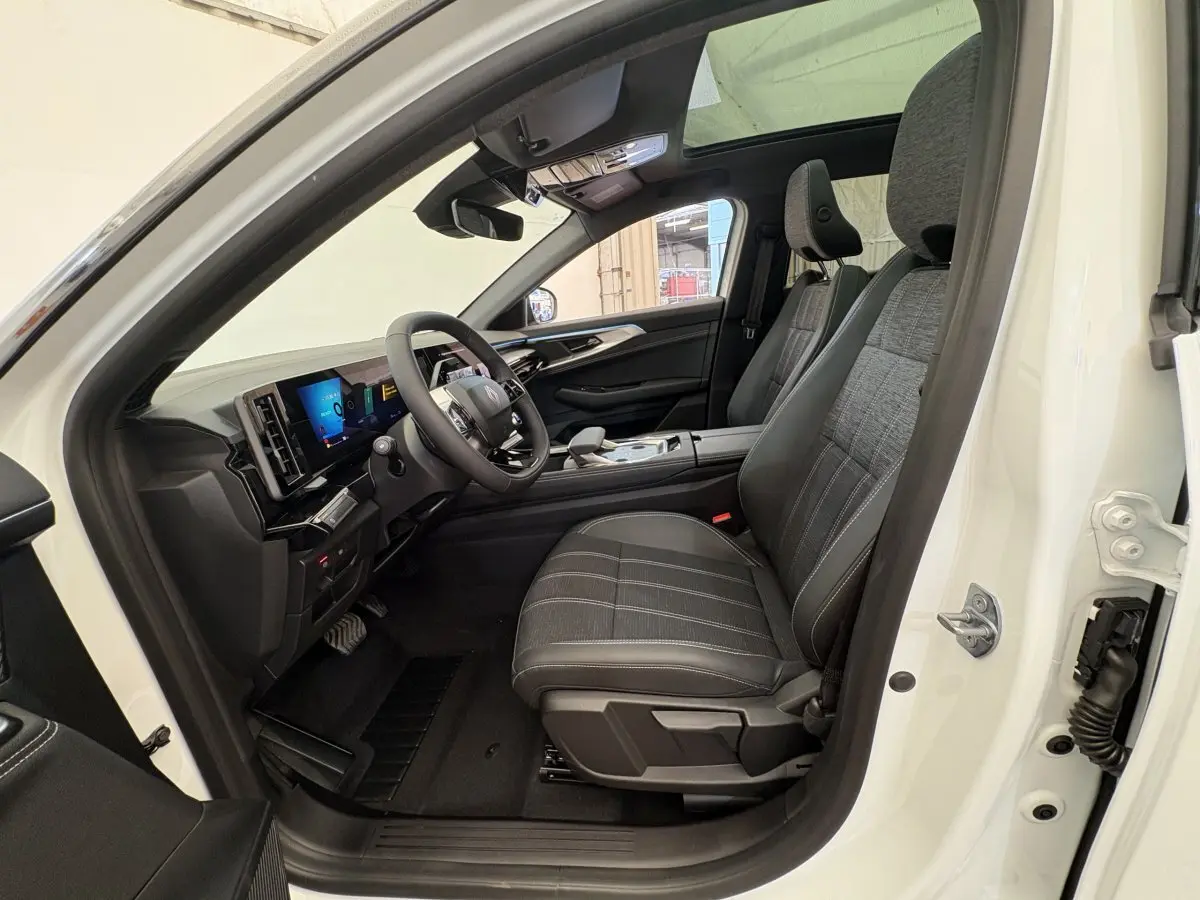 Intérieur côté conducteur du Renault Austral blanc 2025, montrant sièges noirs et tableau de bord avec écran tactile.