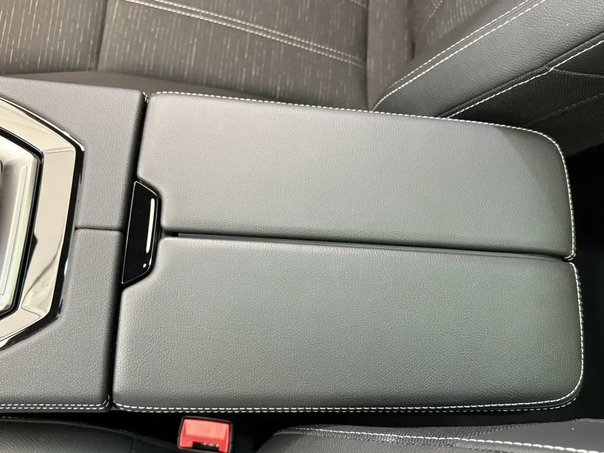 Vue rapprochée du couvercle de la console centrale en cuir noir avec surpiqûres blanches du Renault Austral 2025.