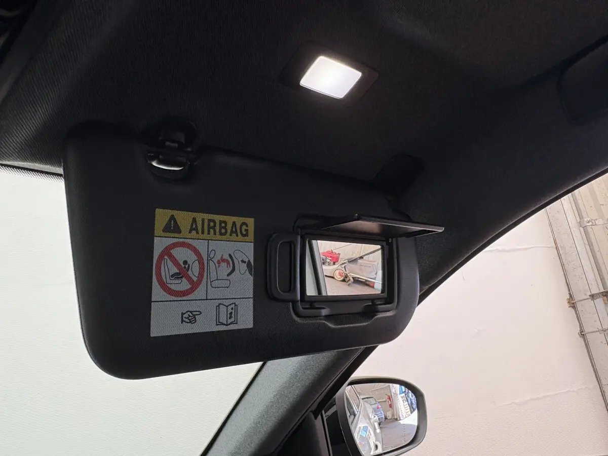 Miroir de courtoisie ouvert sur pare-soleil noir à l'intérieur d'un Renault Austral 2025, vue côté conducteur.