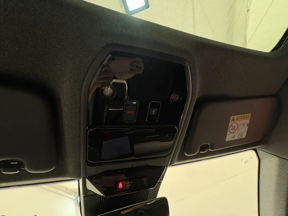 Vue en plongée du plafonnier noir brillant avec bouton SOS et avertissement airbag du Renault Austral blanc 2025.