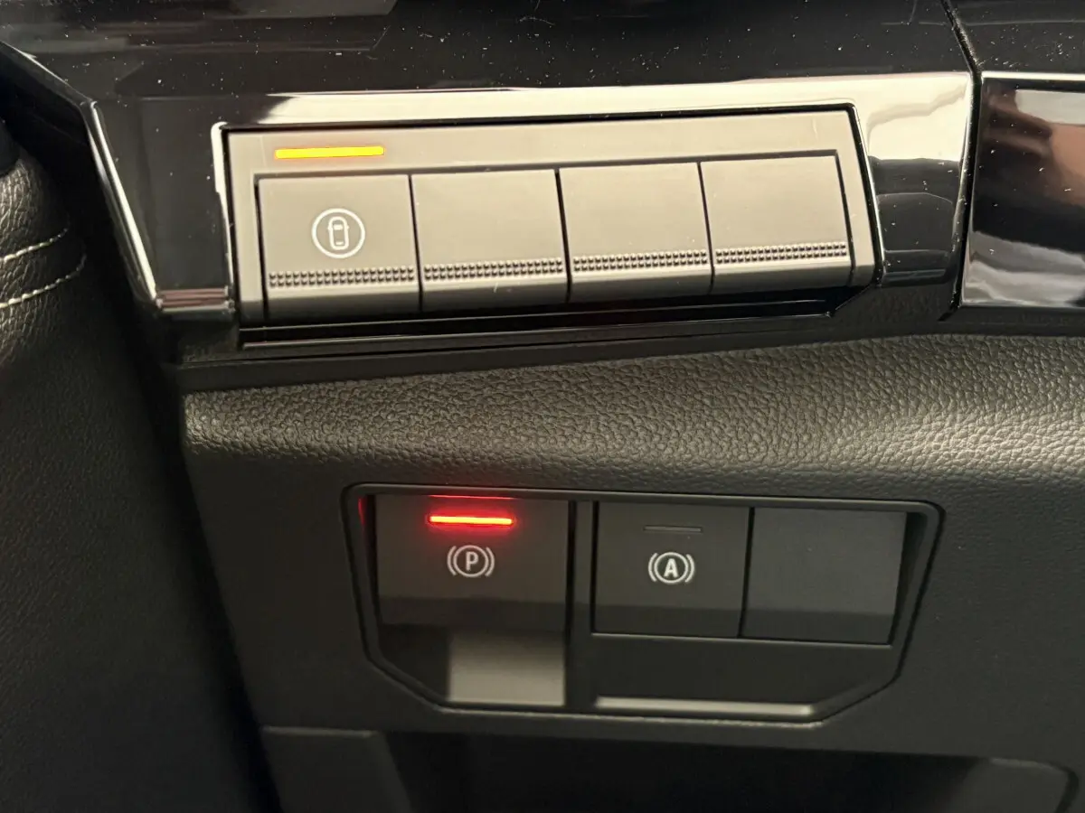 Gros plan sur les commandes de frein à main électrique et arrêt auto du Renault Austral 2025, intérieur noir.