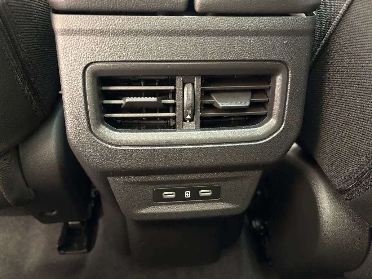 Prise USB double et bouche d'aération arrière centrale noire dans l'habitacle du Renault Austral blanc 2025.