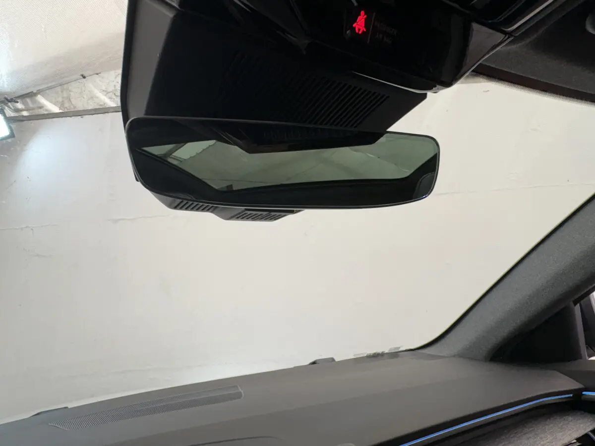 Vue intérieure du rétroviseur central et tableau de bord noir du Renault Austral blanc 2025 hybride.