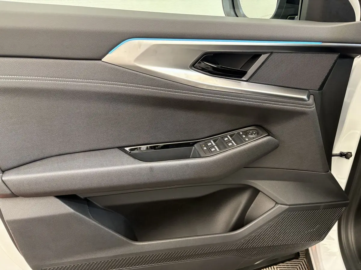 Panneau de porte côté gauche du Renault Austral blanc 2025, avec commandes de vitres et insert décoratif bleu.