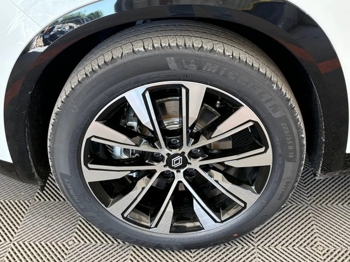 Gros plan sur la roue avant droite blanche du Renault Austral 2025 avec jante alliage noire et argentée design moderne.