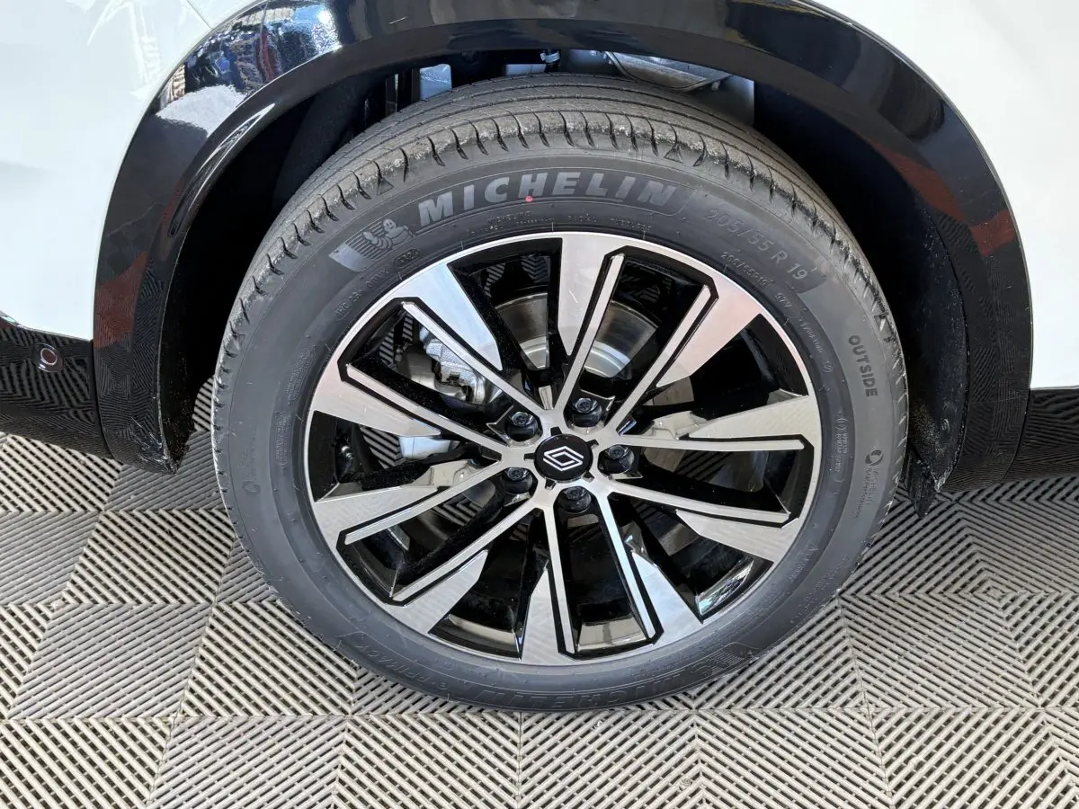 Gros plan sur la roue avant droite du Renault Austral blanc, jante alliage noire et argent avec pneu Michelin.