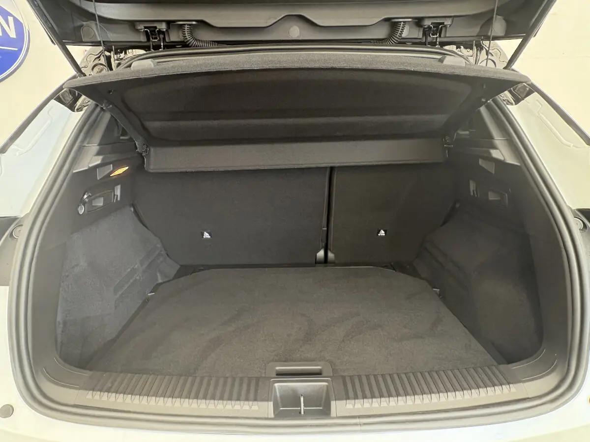 Coffre ouvert vu de l'arrière du Renault Austral blanc 2025, montrant un espace de chargement propre et spacieux.