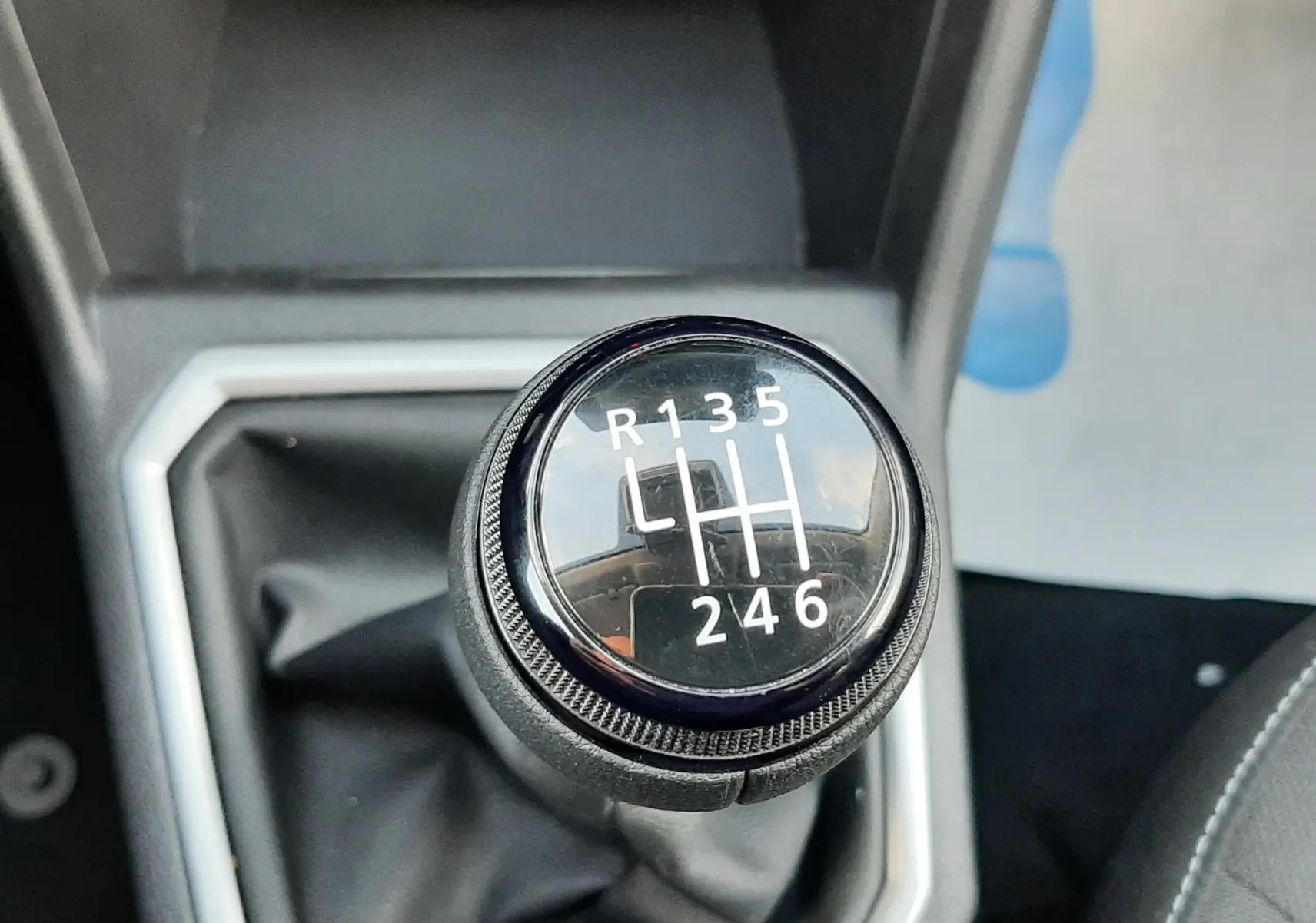 Gros plan sur le levier de vitesses manuel noir du Dacia Jogger 1.0 ECO-G 100CH, entouré d'un cadre gris.