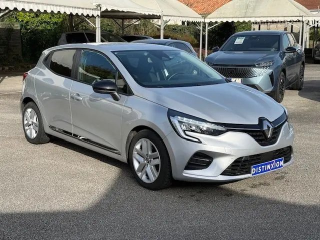 Vue 3/4 avant d'une Renault Clio V gris platine 2021, avec jantes alliage et calandre noire distinctive.