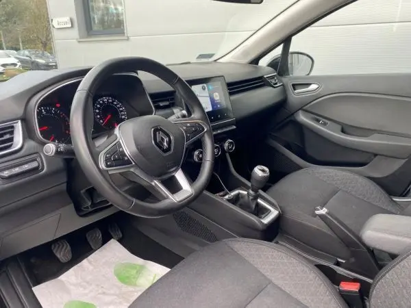 Vue intérieure côté conducteur de la Renault Clio V TCE 90 Zen 2021, tableau de bord moderne et boîte manuelle visible.