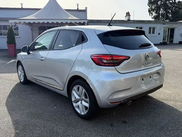 Vue 3/4 arrière droite d'une Renault Clio V TCE 90 Zen gris platine de 2021, avec vitres teintées et jantes alliage.