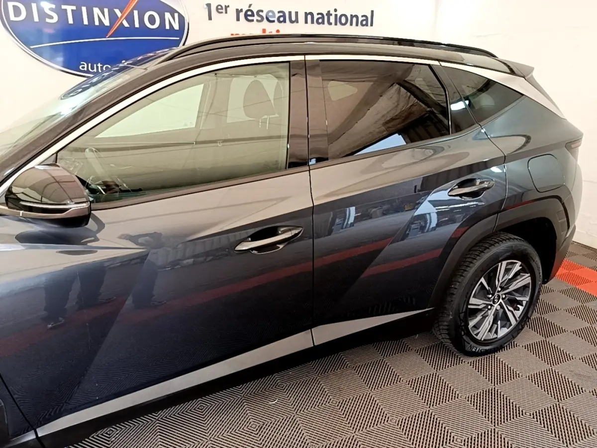 Vue latérale droite d'un Hyundai Tucson gris foncé 2022 avec jantes alliage et poignées chromées.