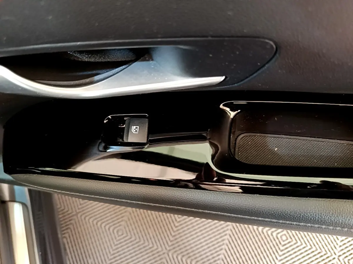 Gros plan sur la commande de lève-vitre côté conducteur du Hyundai Tucson gris foncé 2022, finition Creative.