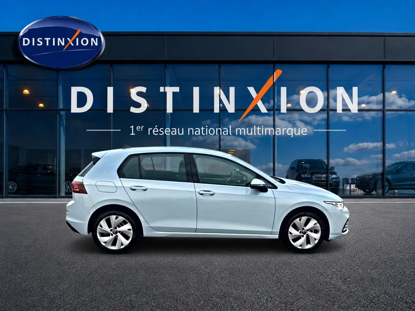Volkswagen Golf 2026 bleu glacier vue de profil côté gauche devant showroom Distinxion.