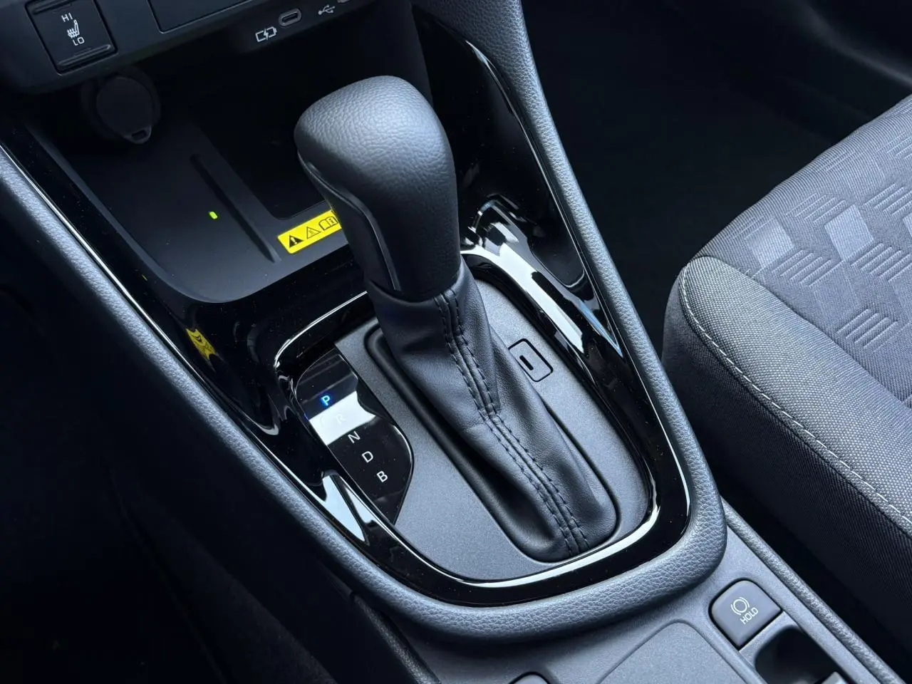 Le levier de vitesse automatique noir de la Toyota Yaris Hybride 2025 vu de dessus côté siège passager.