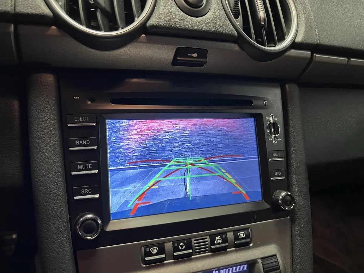 Écran central du tableau de bord d'une Porsche Cayman 2008 affichant la caméra de recul en fonctionnement.