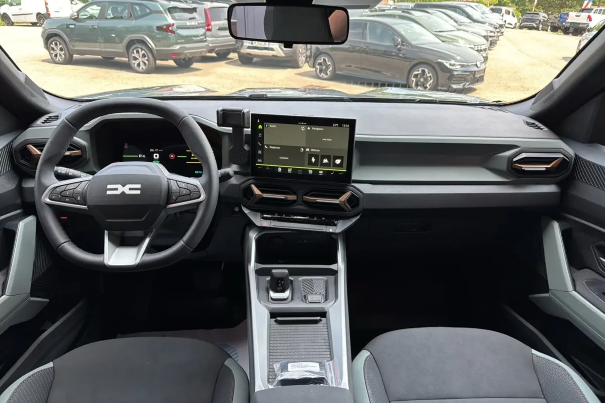 Intérieur moderne du Dacia Bigster Hybrid 155 Extreme Plus 2025, tableau de bord et console centrale vus de face.