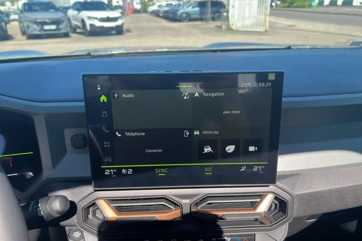 Écran tactile central du tableau de bord du Dacia Bigster Hybrid 155 Extreme Plus 2025 avec commandes climatisation visibles.