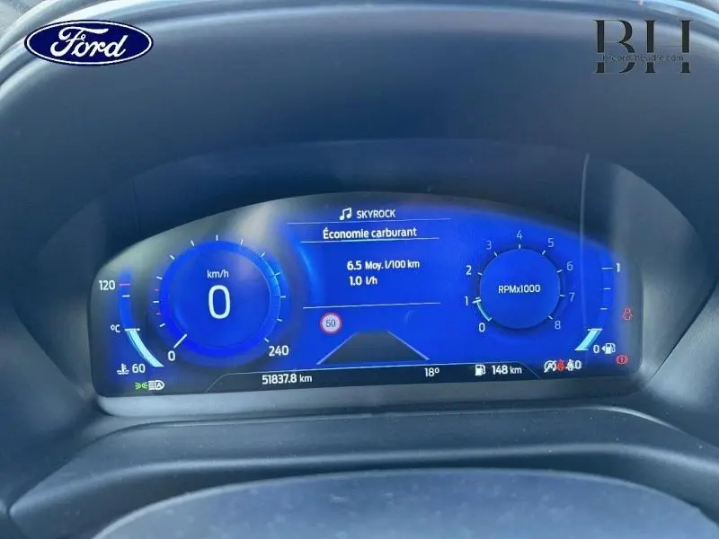 Tableau de bord numérique du Ford Puma 2021 affichant vitesse, régime moteur et consommation, éclairage bleu vif.