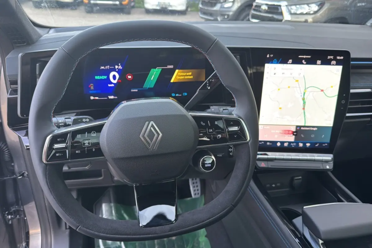 Intérieur Renault Austral New 200 Esprit Alpine, vue centrée sur le volant cuir et l'écran tactile avec navigation affichée.