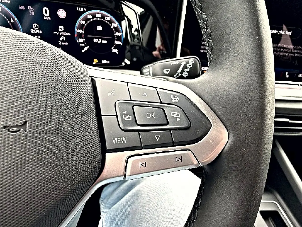 Gros plan sur le volant noir avec commandes intégrées et tableau de bord digital de la Volkswagen Golf 1.5 bleu glacier 2026.