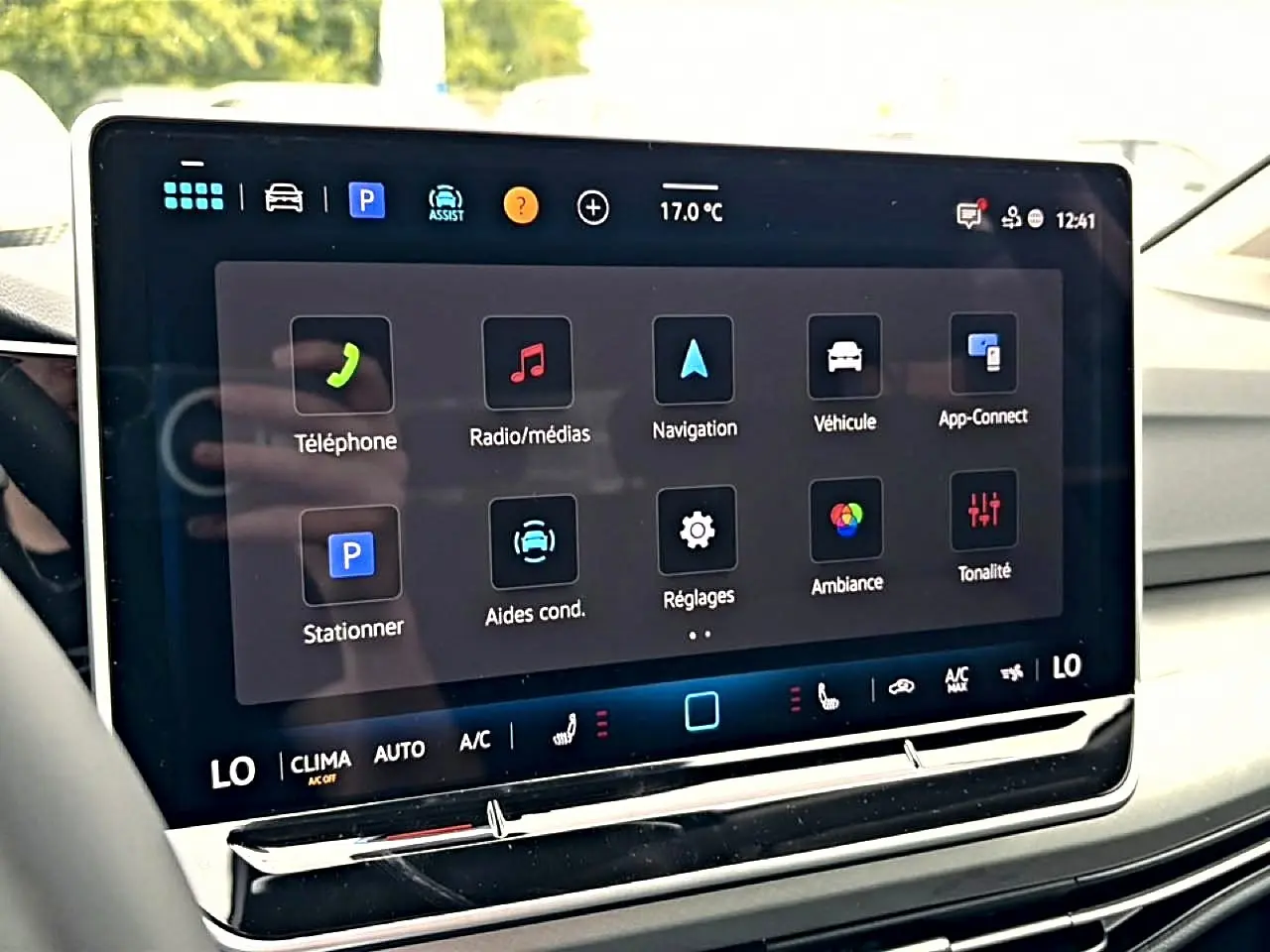 Écran tactile central de la Volkswagen Golf 2026 montrant les options de navigation et médias, intérieur clair.