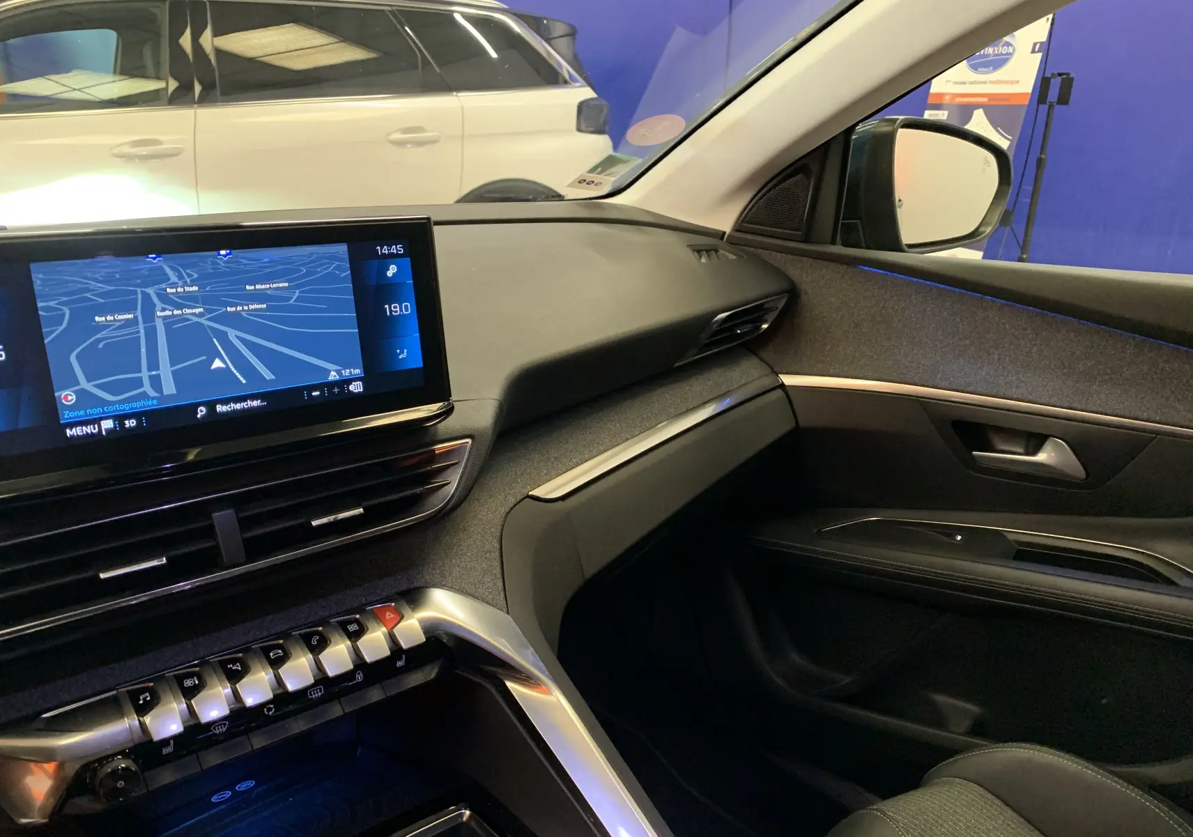 Intérieur côté passager du Peugeot 3008 bleu, tableau de bord moderne avec écran tactile et finitions tissu gris.
