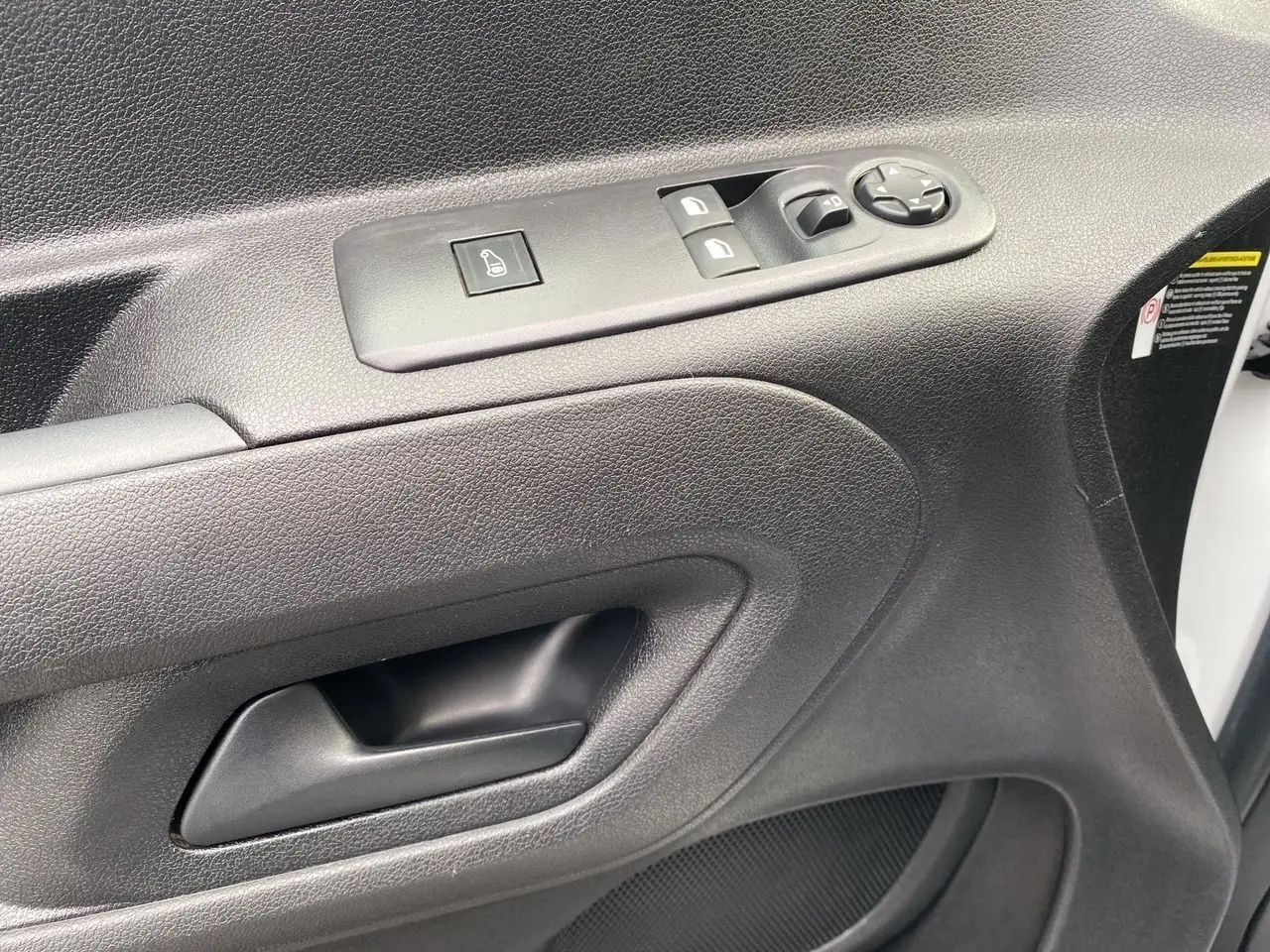 Gros plan sur la porte côté conducteur blanche du Citroën Berlingo 2019 avec commandes électriques et poignée noire.