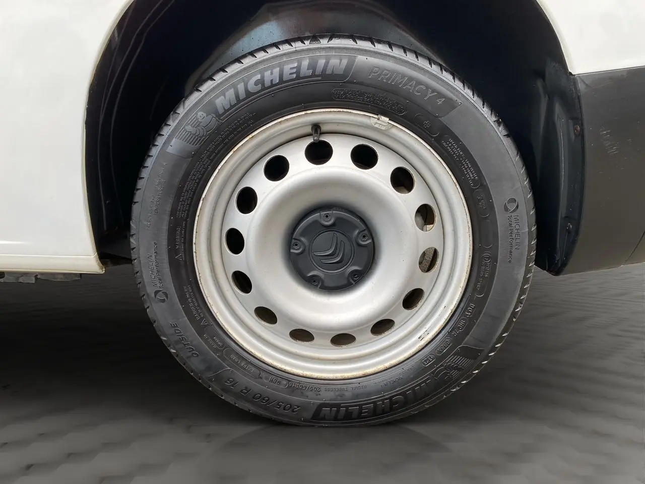 Gros plan sur la roue avant gauche d'un Citroën Berlingo blanc de 2019, avec jante acier et pneu Michelin.