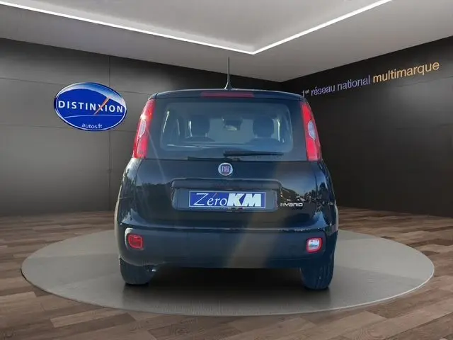 Vue arrière d'une Fiat Panda noire 2025 avec feux verticaux et plaque Zero KM dans un showroom.
