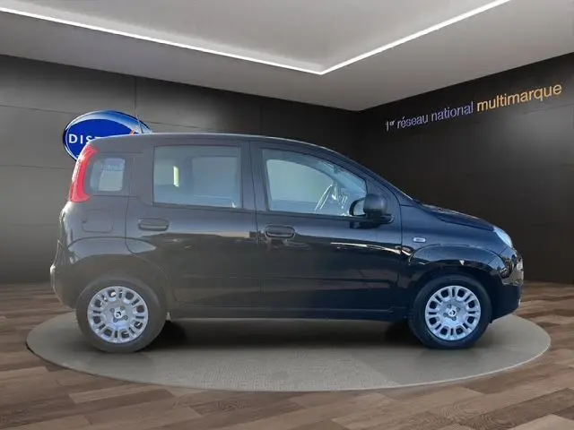 Profil côté droit de la Fiat Panda noire 2025, compacte 5 portes avec jantes acier et vitres teintées, en intérieur showroom.