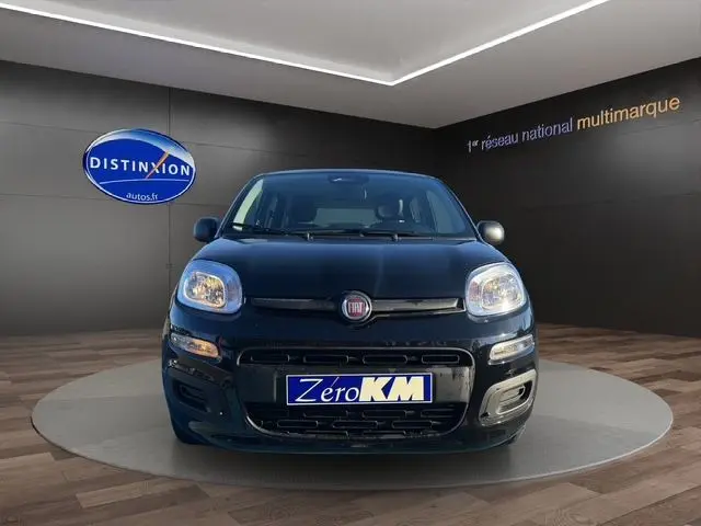 Vue frontale d'une FIAT Panda noire 2025 exposée en showroom avec plaque Zero KM visible.