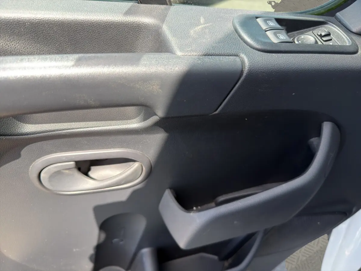 Gros plan sur la porte intérieure côté conducteur du Renault Master 2024, avec commandes électriques et poignée noire.