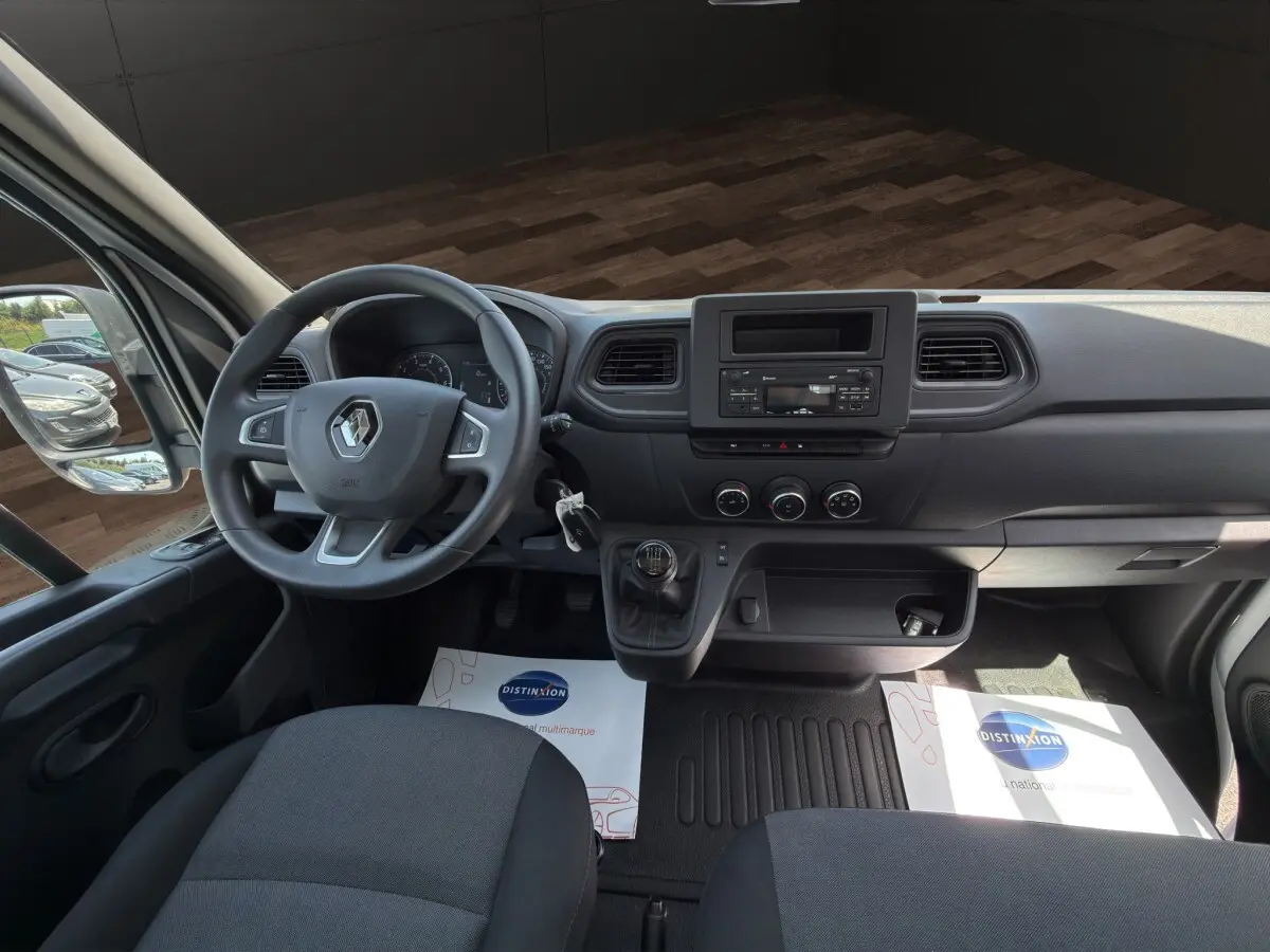 Vue intérieure avant du Renault Master 2024, montrant le volant, tableau de bord noir et levier de vitesse manuel.