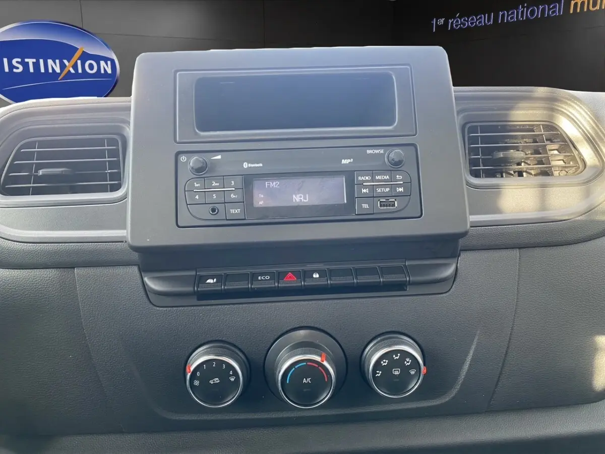 Vue rapprochée du tableau de bord noir du Renault Master 2024 avec commandes climatisation et radio affichant NRJ.