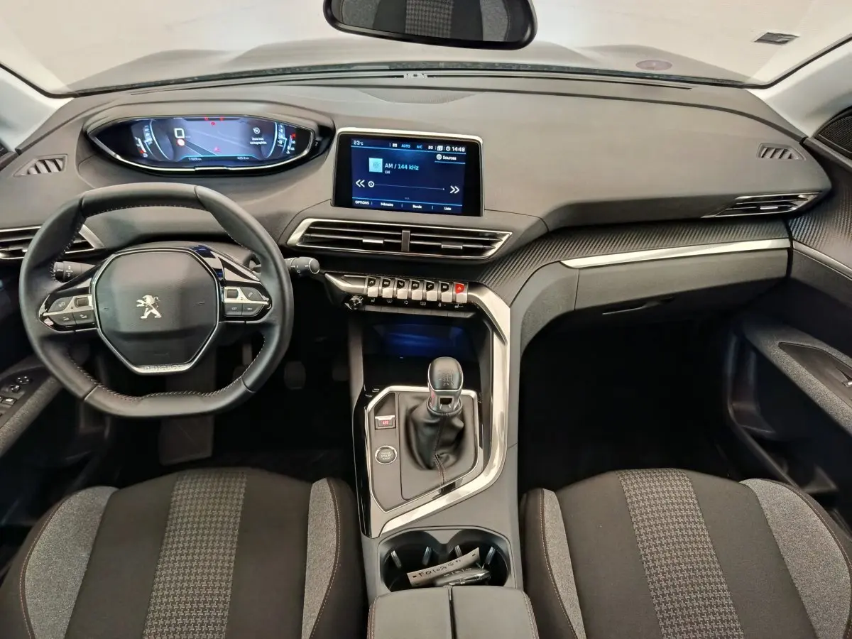 Vue intérieure avant du Peugeot 3008 gris foncé, avec tableau de bord numérique et console centrale équipée d'une boîte manuelle.