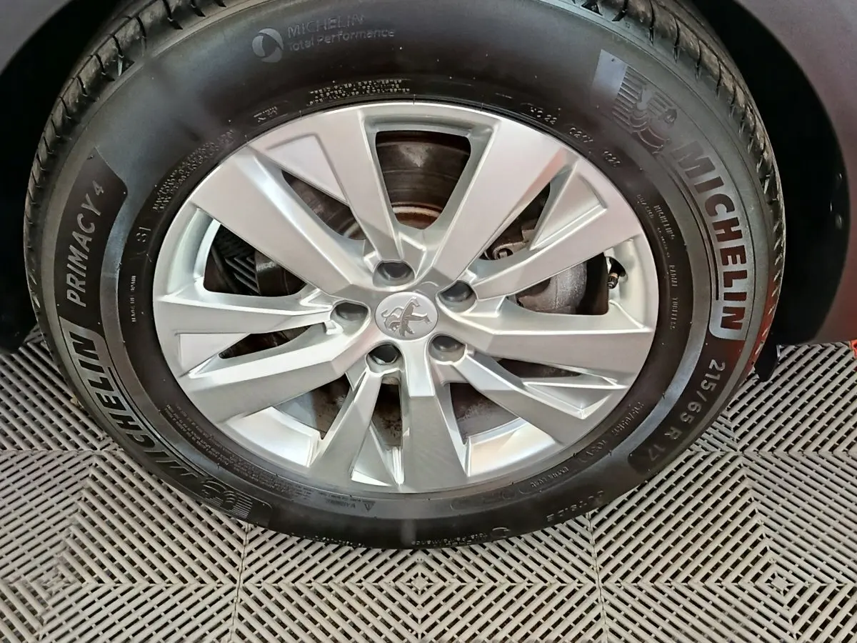 Gros plan sur la roue avant droite d’un Peugeot 3008 gris foncé, jante alliage et pneu Michelin Primacy 4.